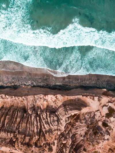 Turquoise Waves Crashing Against Rocky Coastal Formation