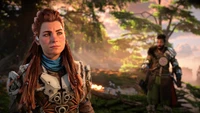 Aloy se mantiene decidida en un paisaje exuberante y vibrante, con un compañero parcialmente visible en el fondo, personificando el espíritu de aventura en "Horizon Forbidden West".