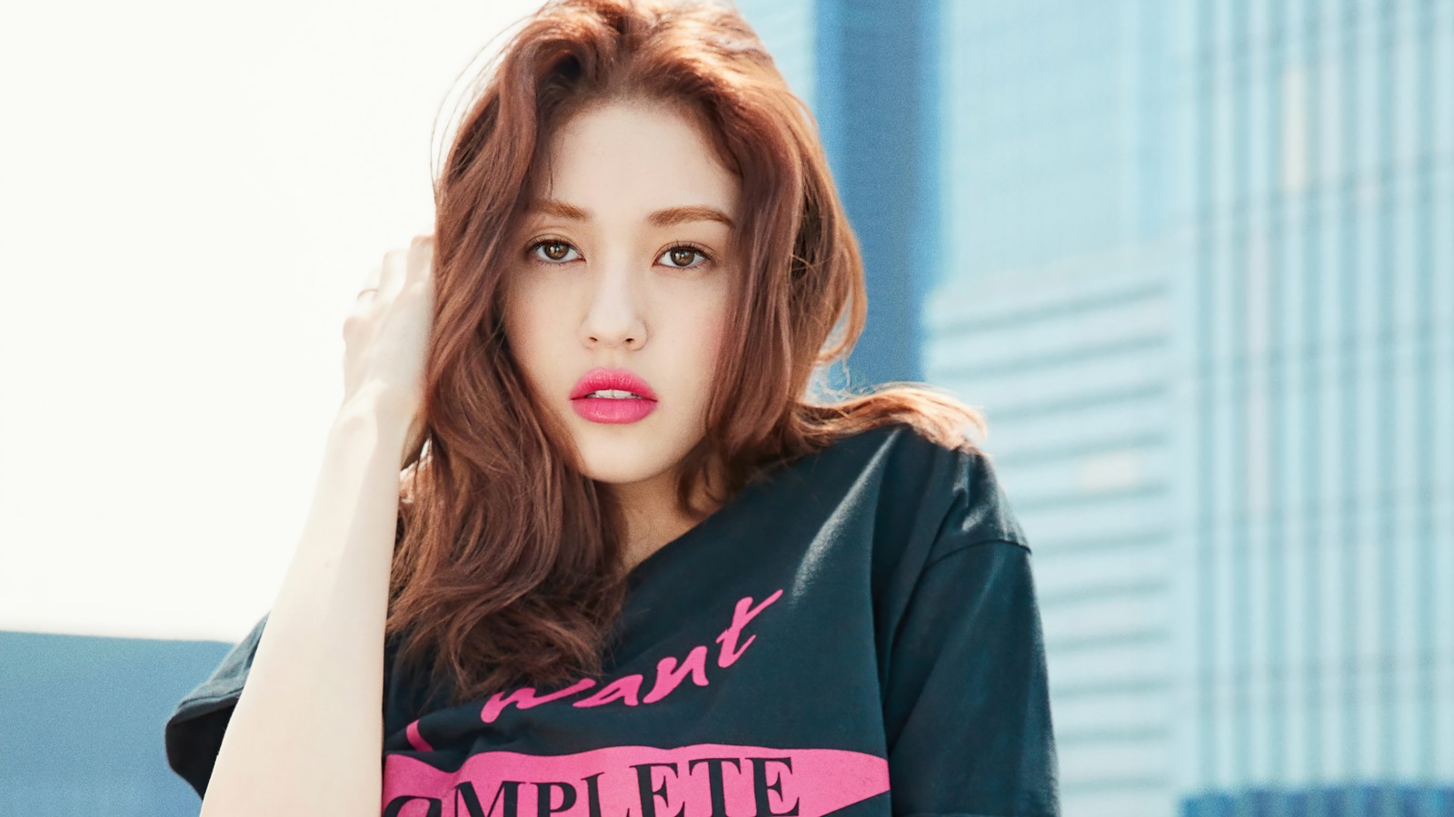 Un primer plano de una mujer con una camisa negra y lápiz labial rosa (somi, 소미, ennik somi douma, jeon somi, jeon so mi)