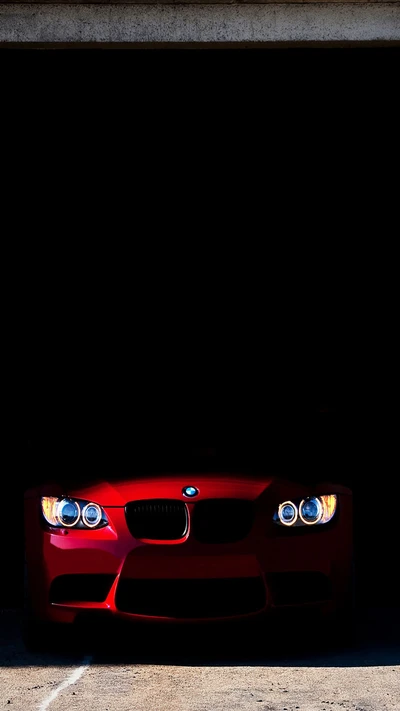 BMW vermelho emergindo das sombras