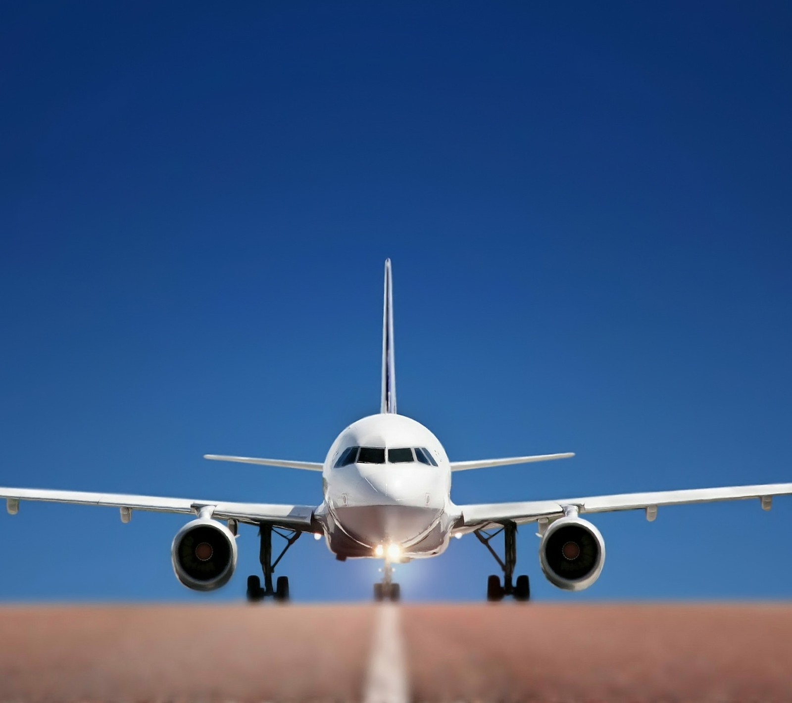 Araflane landing on runway with clear blue sky in background (airplane, landing, perfect, sunshine)