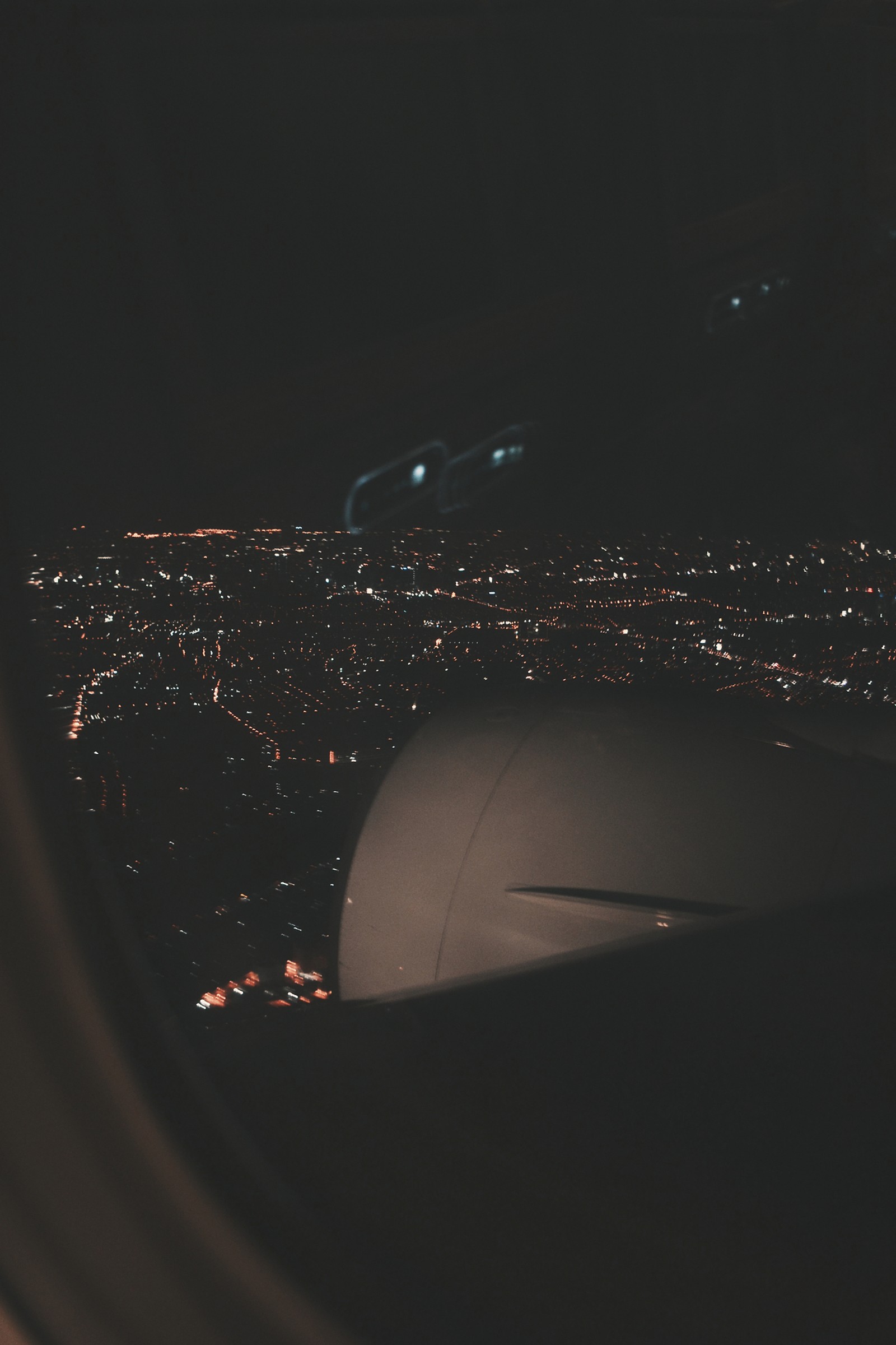 Vue nocturne d'une ville depuis la fenêtre d'un avion (air, ville, voler, lumières, nuit)