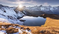 Atemberaubende alpine Landschaft mit einem reflektierenden Tümpel bei Sonnenaufgang