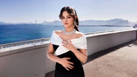 Selena Gomez in an elegant off-the-shoulder dress by the sea.