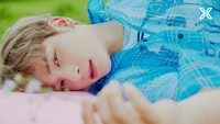 Hangyul in a serene outdoor setting, resting on a pink surface, with soft greenery in the background.