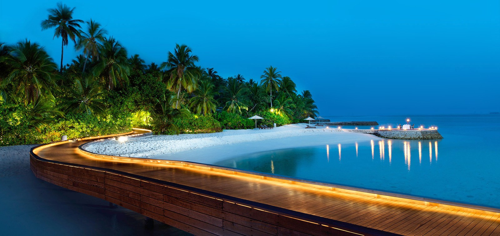 A view of a dock with a boat on the water and palm trees (beach, island, resort, swimming pool, tropics)