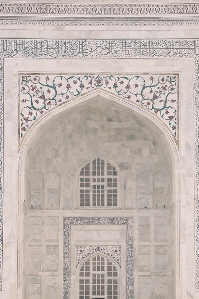 Intrincadas esculturas em pedra e arcos elegantes da arquitetura clássica no Taj Mahal, exibindo a arte medieval e o design sagrado.