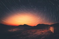 Stunning Sunset with Star Trails Over a Serene Landscape