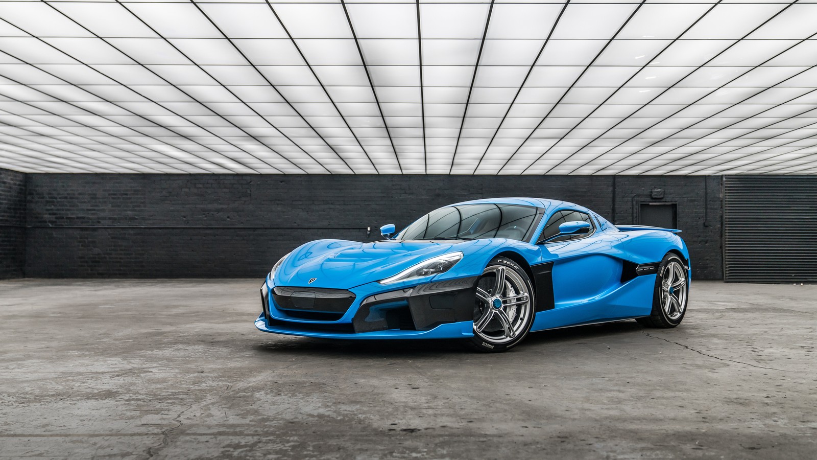 A blue sports car parked in a garage with a black wall (car, sports car, supercar, blue, coup)