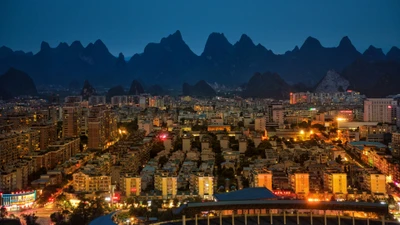 Paisagem urbana noturna do condado de Yangshuo cercada por montanhas majestosas