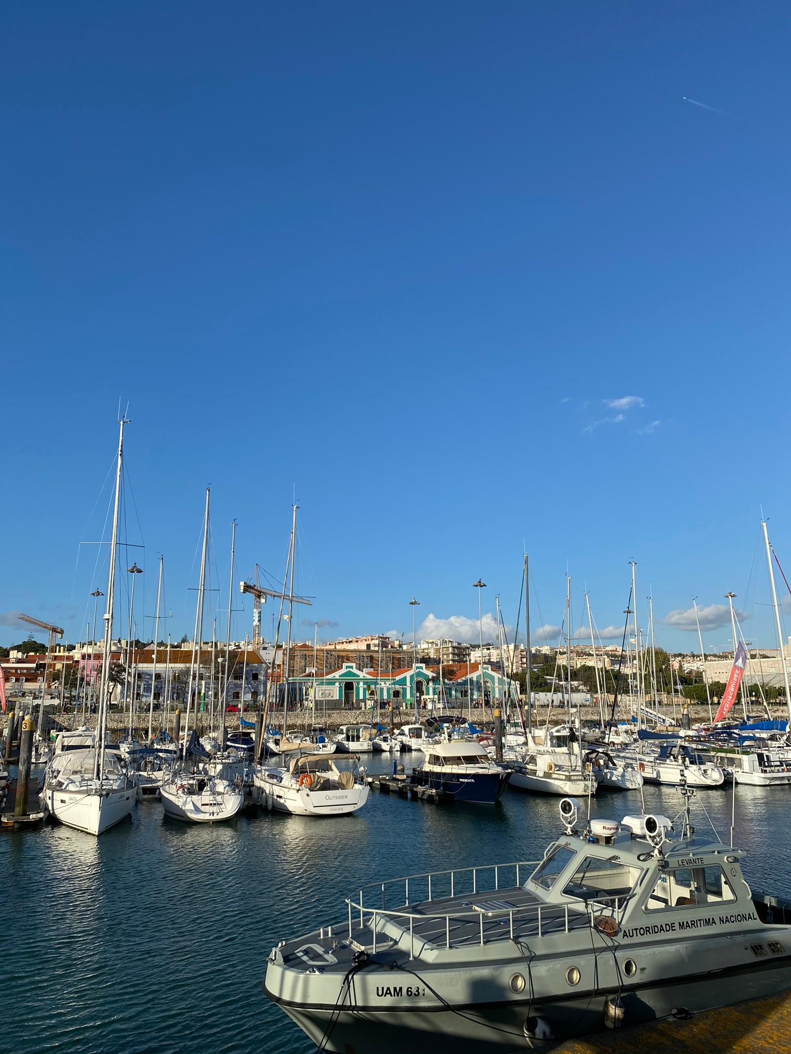 Os barcos estão atracados em um porto com um céu azul ao fundo (marina, navio, embarcação, barco, porto)