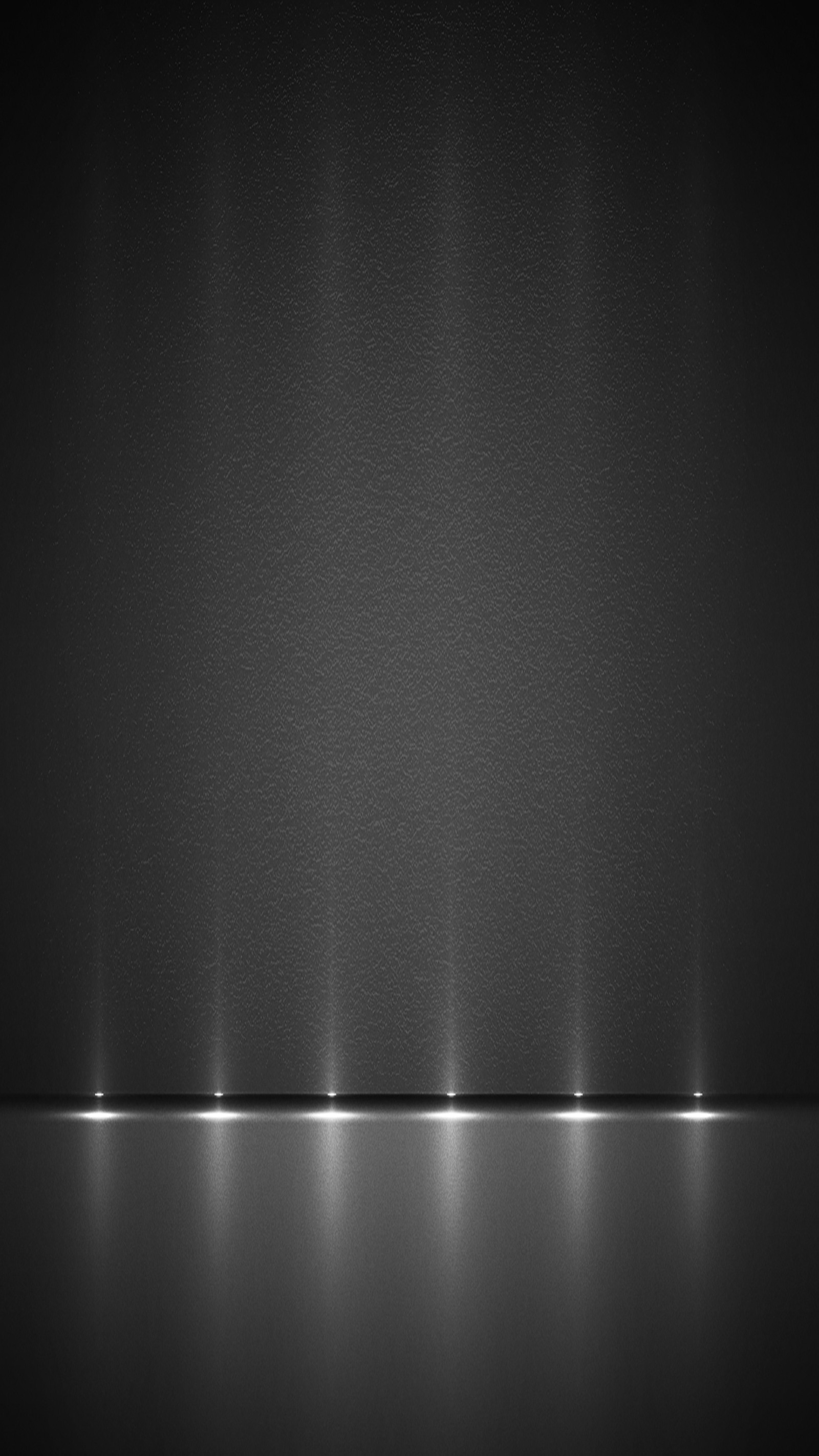 A black and white photo of a row of lights on a wall (silver, wallpaper)