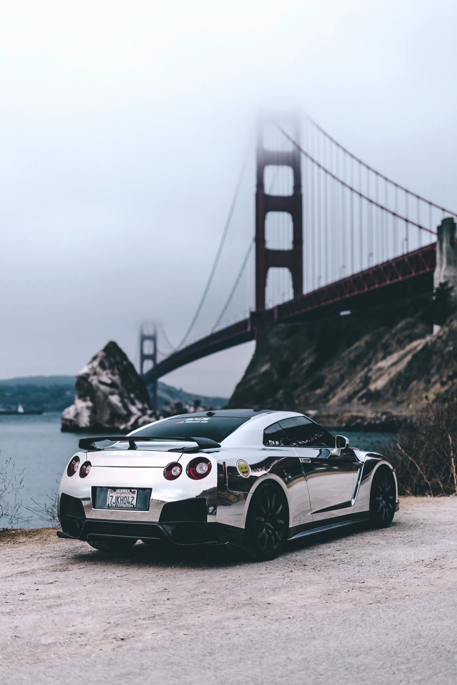 A close up of a car parked near a bridge near water (cars, nissan, nissan gtr)