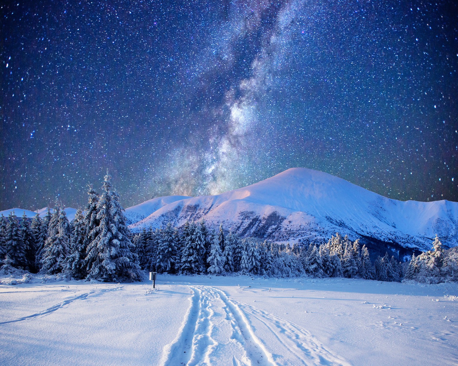 A snowy landscape with tracks in the snow and a milky in the sky (landscape, mountains, nature, night, sky)