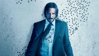 Keanu Reeves dans un costume bleu élégant au milieu d'un décor dramatique, dégageant une élégance cool et une allure prête à l'action.