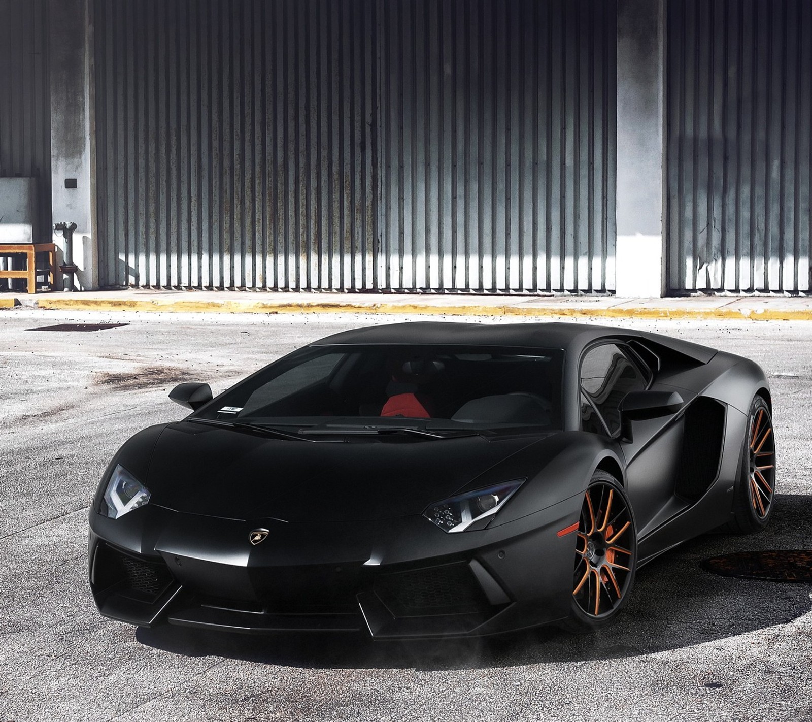 A close up of a black sports car parked in a parking lot (bike, car, entertainment, faster, latest)