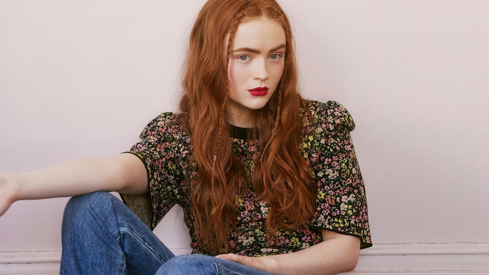 Femme arabe avec des cheveux rouges assise par terre les jambes croisées (sadie sink, américain, actrice, célébrité, filles)