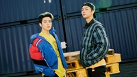 Jaehyun e Johnny do NCT 127 em um ambiente urbano estiloso, exibindo sua moda vibrante e carisma para o álbum "Neo Zone".