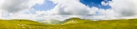 Amplio paisaje de tierras altas bajo un cielo dramático