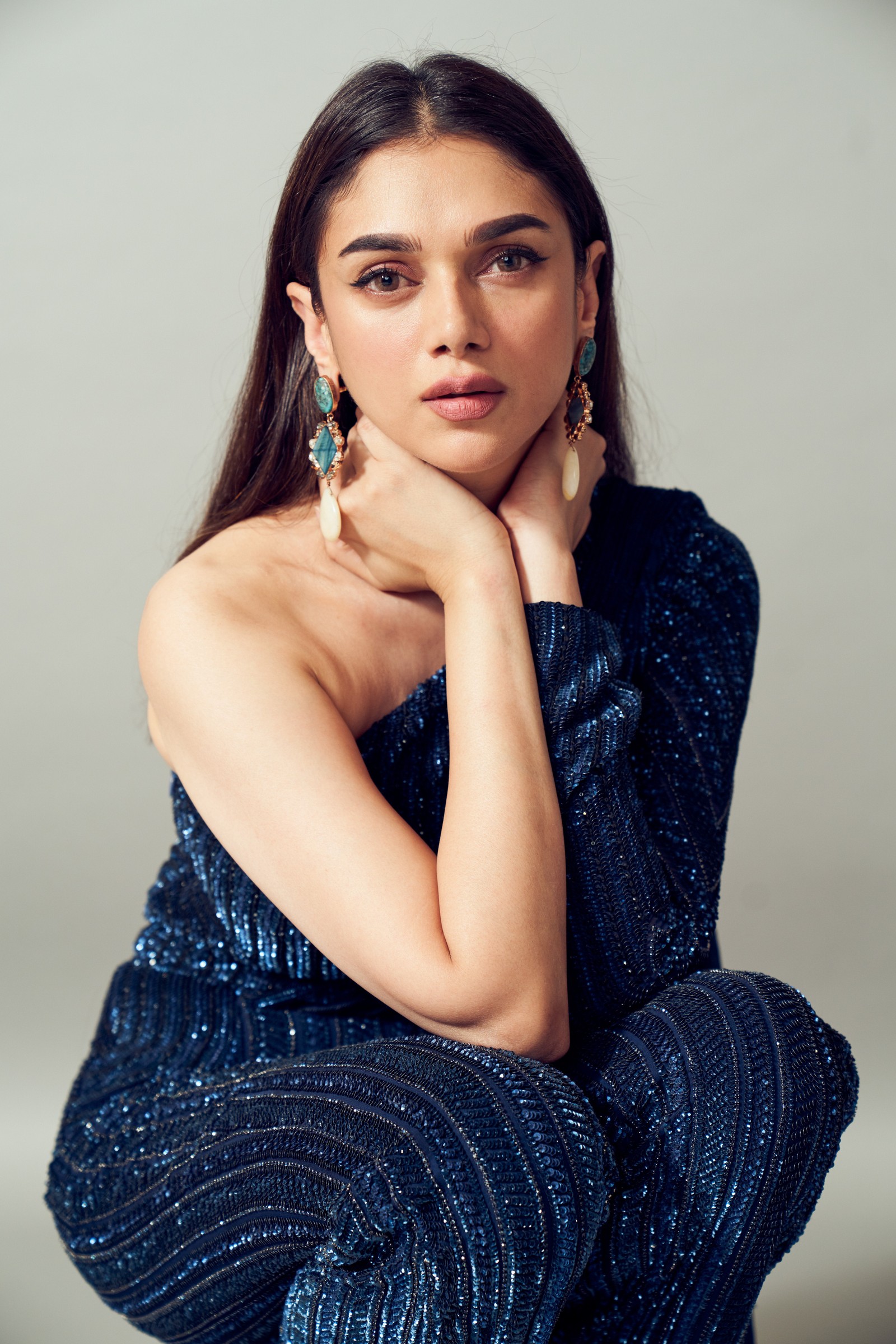 Une femme en robe bleue assise sur un tabouret avec sa main sur son menton (aditi rao hydari, actrice indienne, actrice de bollywood, 5k, gens)