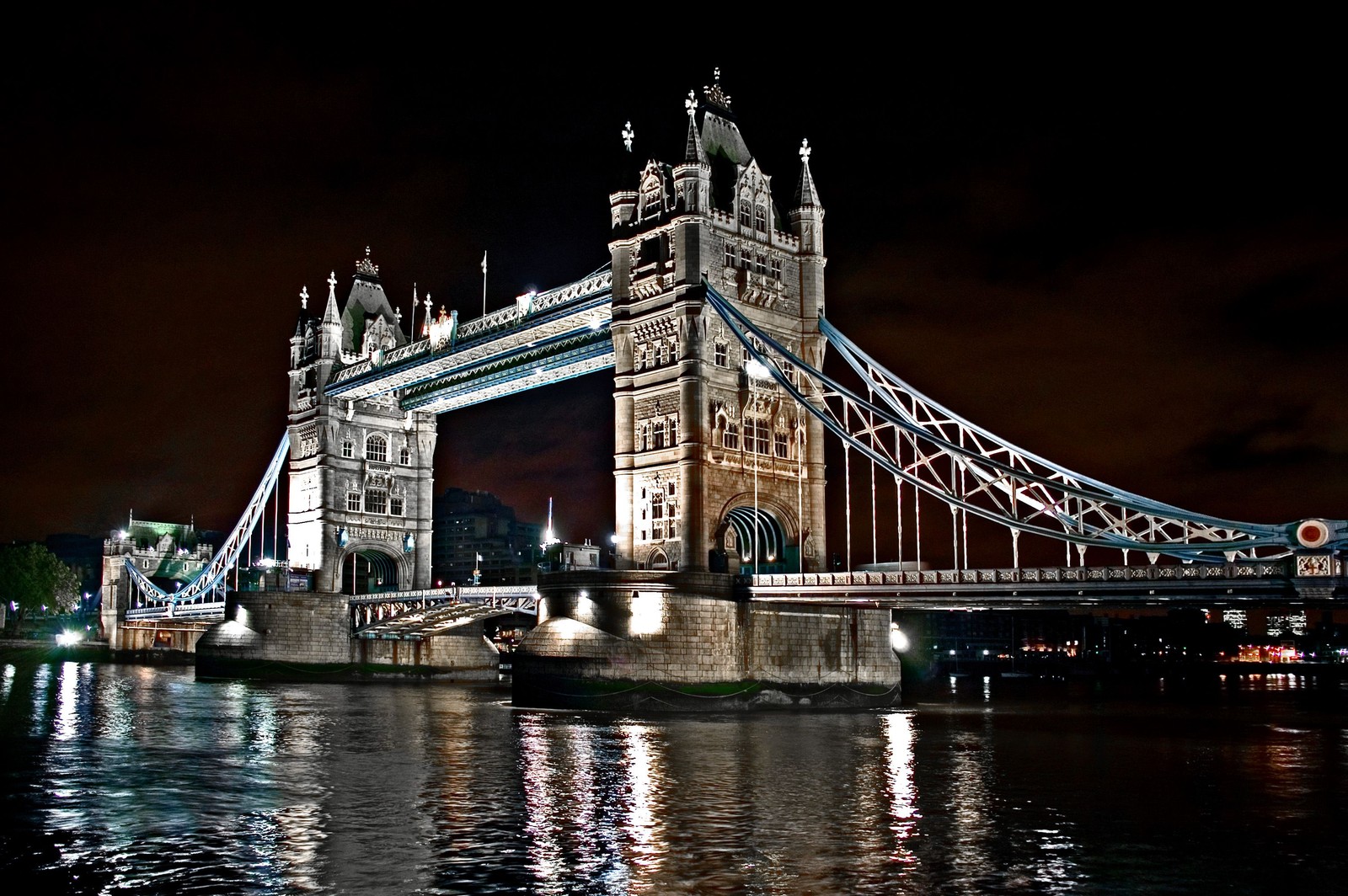 Ponte arqueada sobre a água à noite com luzes acesas (tower bridge, rio tâmisa, ponte, marco, noite)