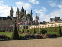 Medieval Cathedral Surrounded by Lush Gardens and Historic Flags