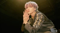 Taeyong do NCT U em uma pose marcante, exibindo um traje estiloso adornado com enfeites, exalando carisma e arte do álbum "Make a Wish: Resonance Pt. 1".