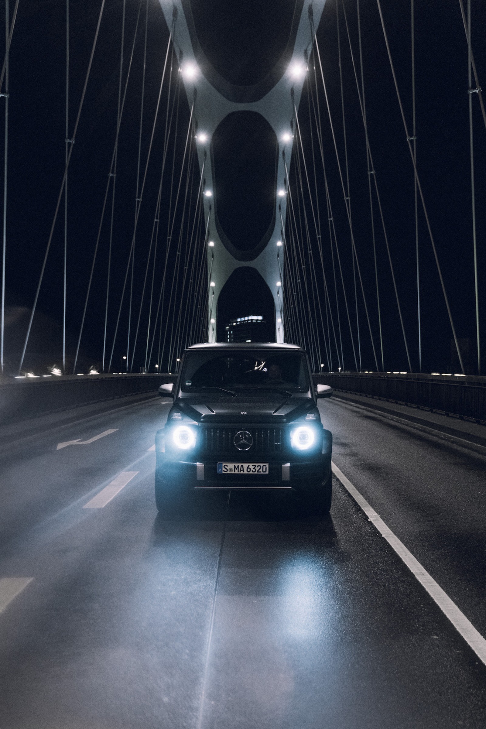 Un coche conduciendo sobre un puente por la noche con las luces encendidas (amg, araba, arabalar, coche, coches)