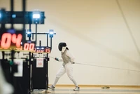 Fencer Competing in a Match with Foil and Electronic Scoring System