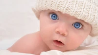 Bébé aux yeux bleus et bonnet tricoté