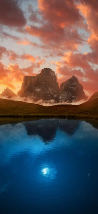 Montanhas majestosas refletindo em um tranquilo lago de montanha ao pôr do sol