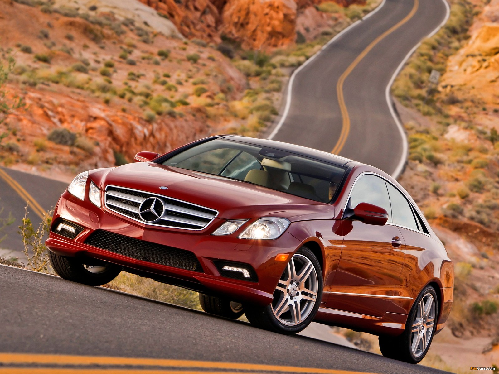 Um close de um mercedes cls vermelho dirigindo por uma estrada sinuosa (carro, golpe, carro médio, carro de luxo, mercedes benz e class)