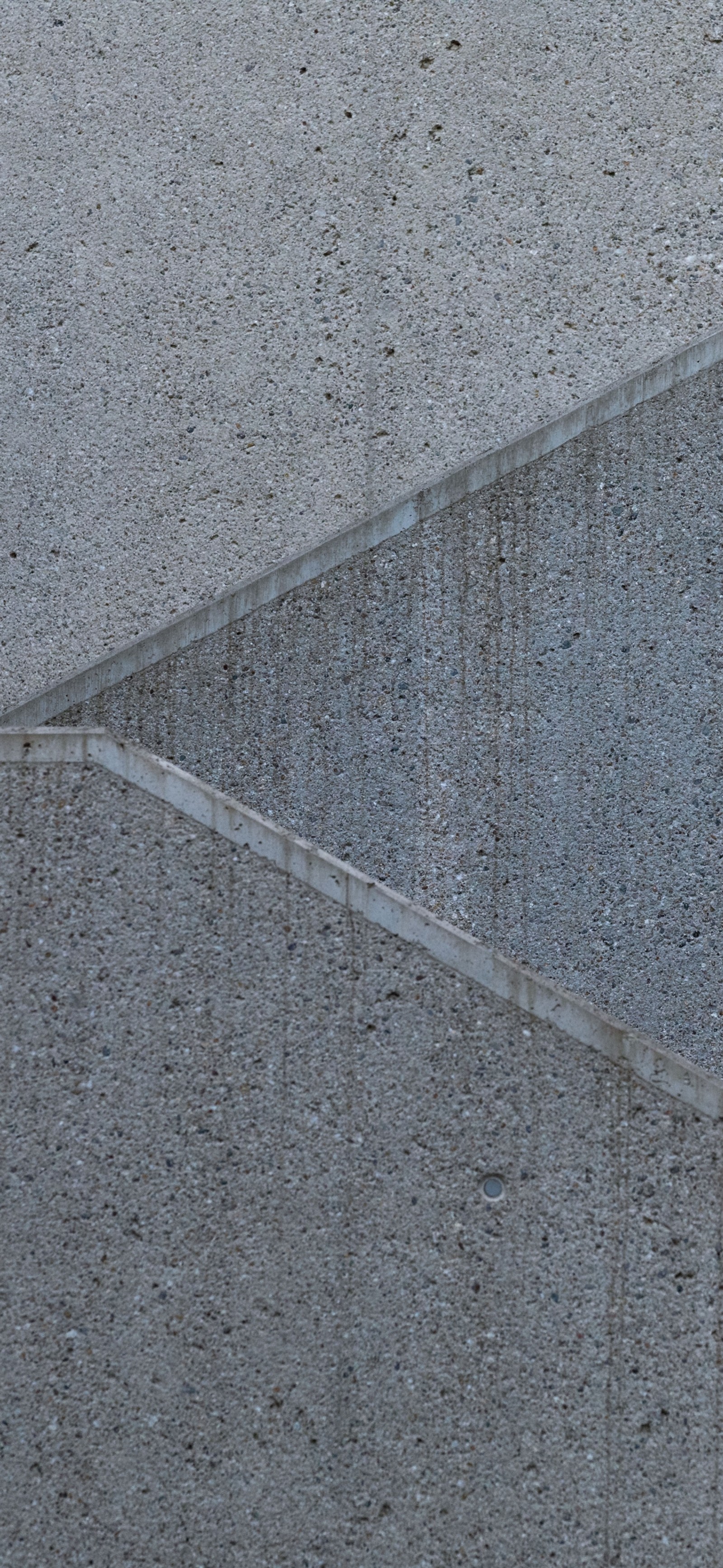 There is a man walking down a sidewalk with a umbrella (asphalt, concrete, road surface, geometry, mathematics)