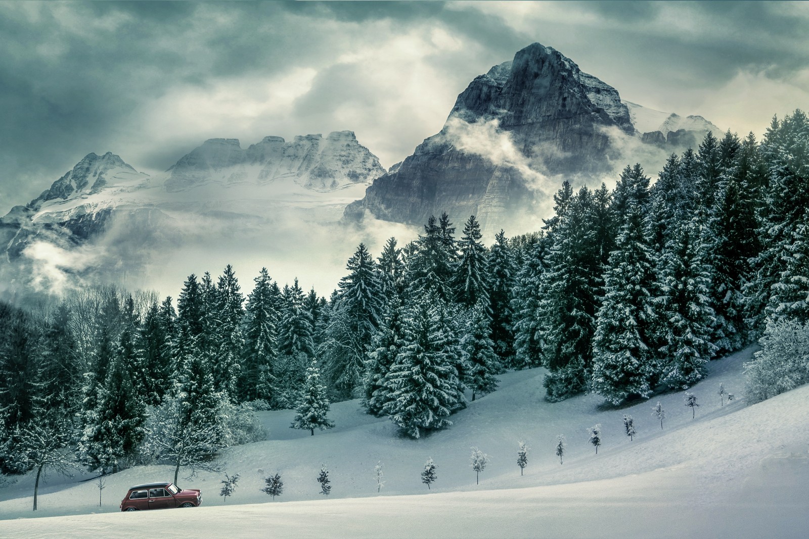 Une voiture roulant sur une route enneigée dans les montagnes (pins, hiver, forêt, montagnes, sommet)