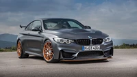 BMW M3 в динамичной уличной обстановке с эффектными колесами и облачным фоном