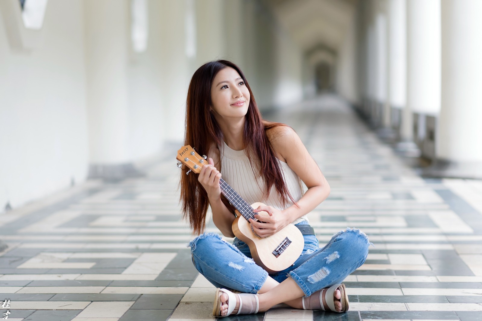 Une femme arabe assise par terre jouant du ukulélé (guitare, assis, beauté, cheveux longs, tambours)