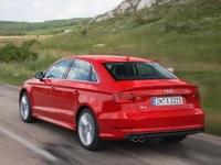 Audi A3 Sedan vermelho em movimento em uma estrada cênica