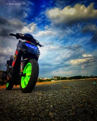 Moto Aprilia SR 150 avec des accents verts contre un ciel dramatique