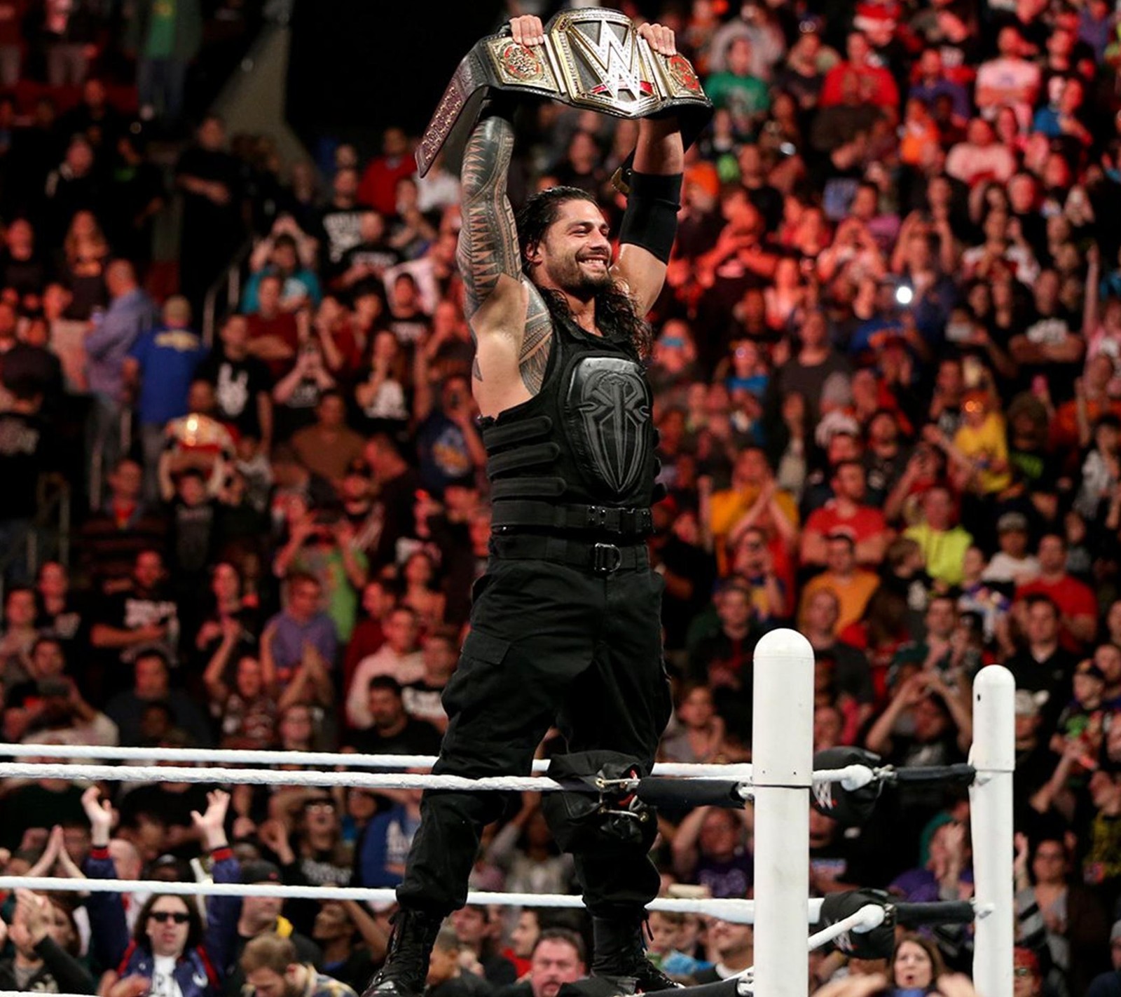 A man holding a trophy in the air in front of a crowd (entertainment, hollywood, raw, smackdown, superstars)