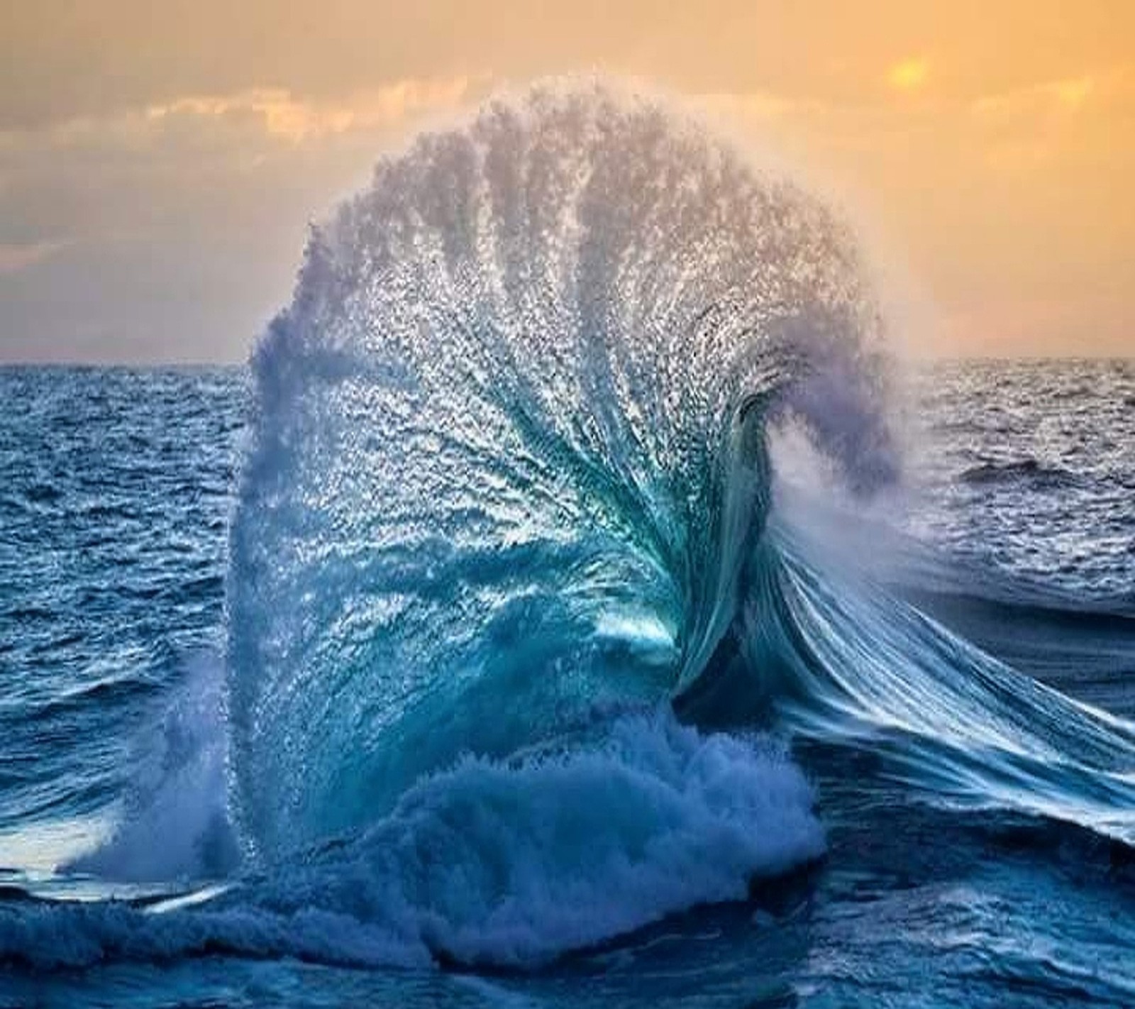 Vague se brisant dans l'océan au coucher du soleil avec un ciel en arrière-plan (incroyable, vague)