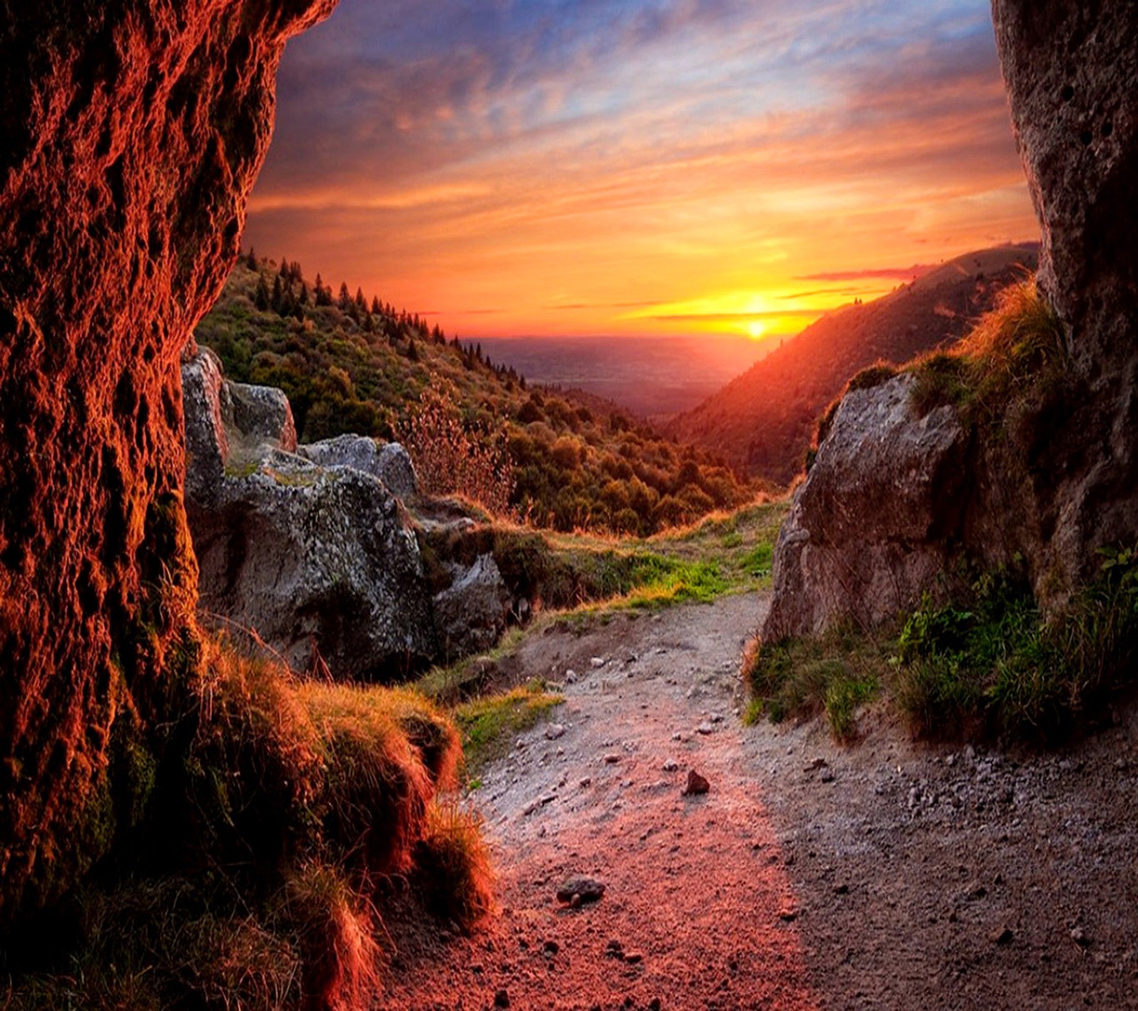 Vue d'un coucher de soleil depuis une grotte dans les montagnes (beau paysage, coucher de soleil)