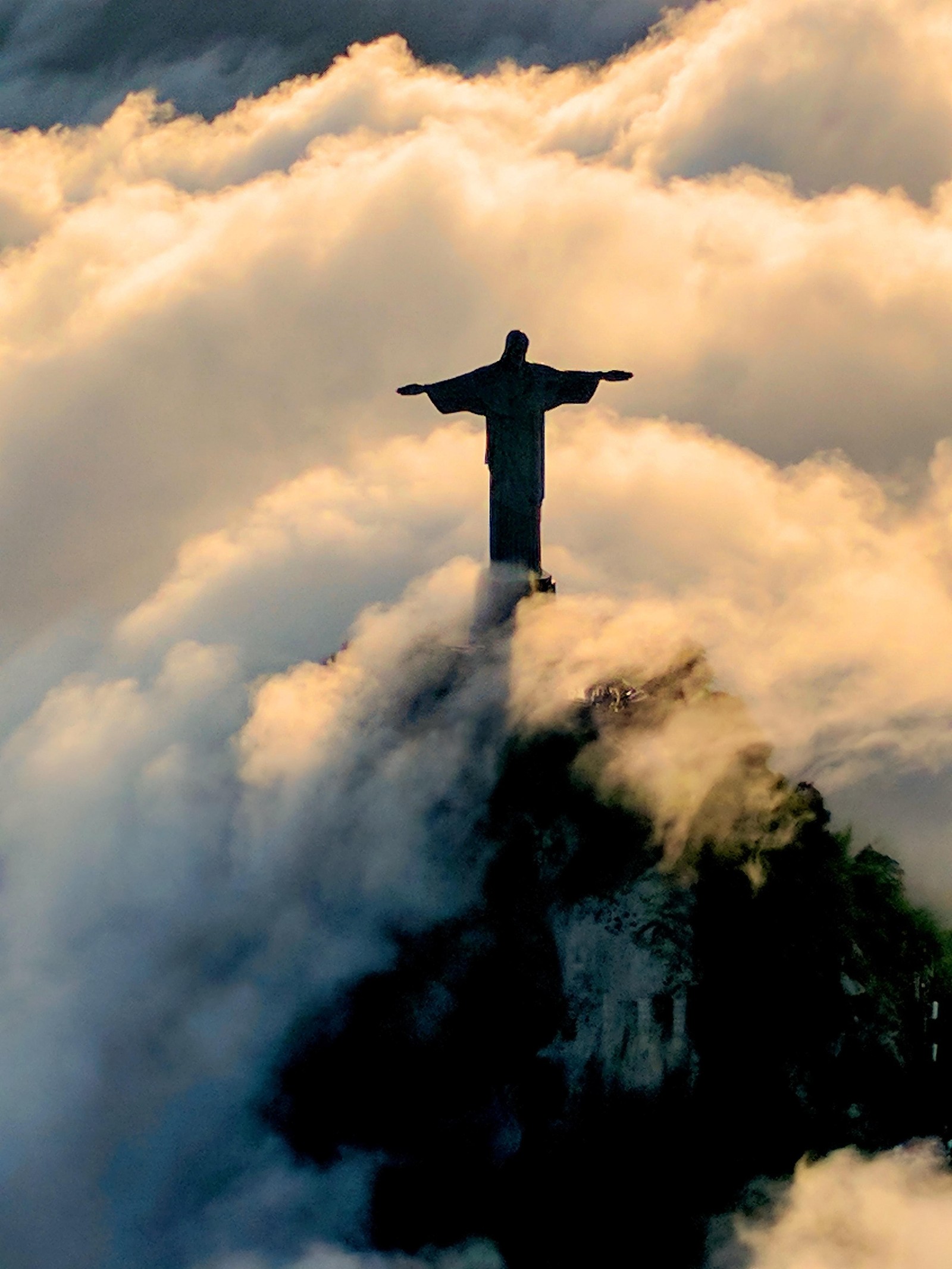 Une statue arafed d'une girafe dans les nuages au-dessus d'une montagne avec un fond de ciel. (ange, anges, chrétien, christianisme, croix)