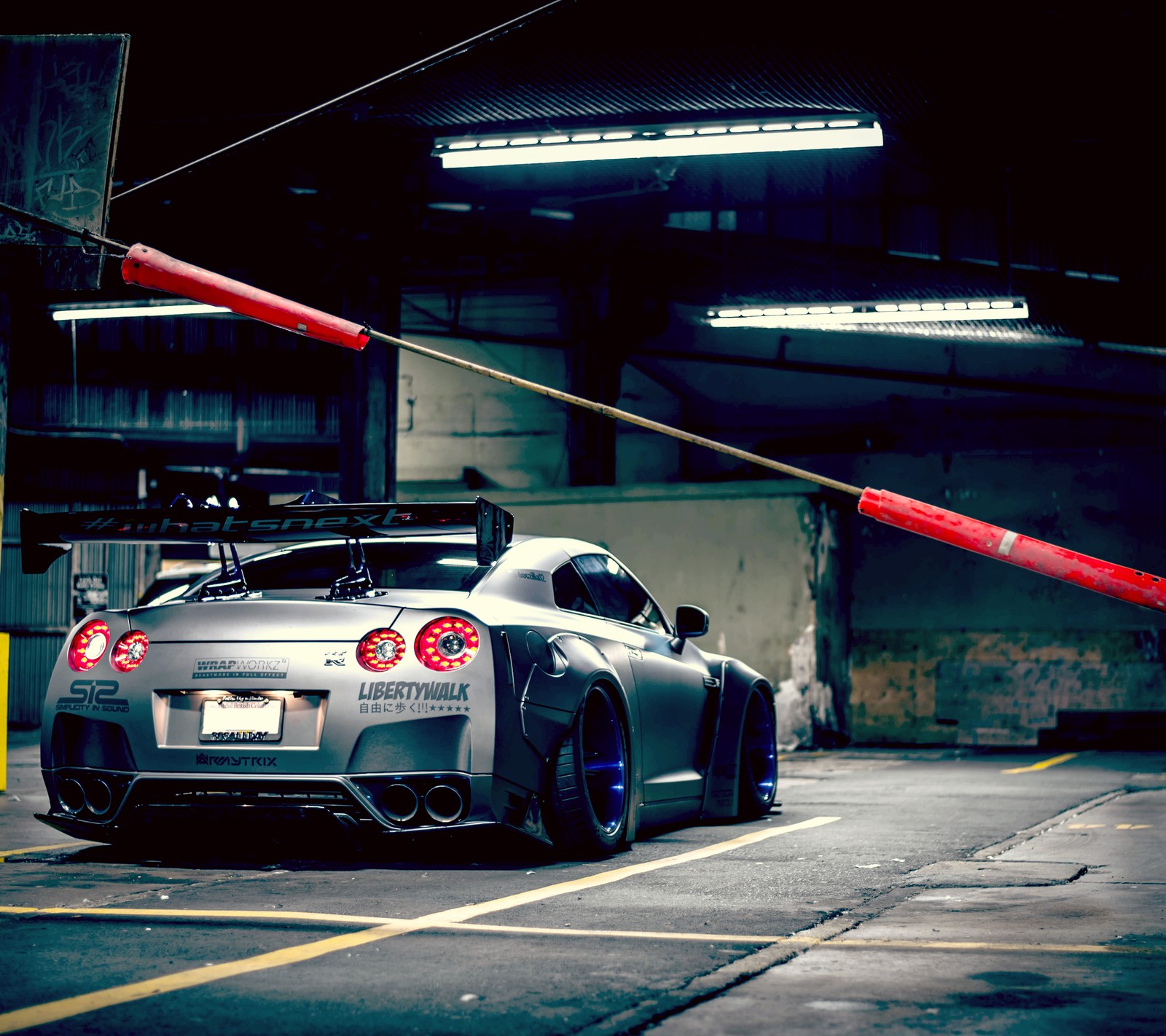 Arafed sports car parked in a parking garage with a red pole (blue, dark, gtr, nissa, racing)