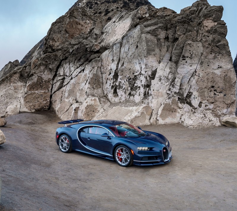 Близкий план автомобиля bugatti, припаркованного перед горой (синий, франция, суперкар)