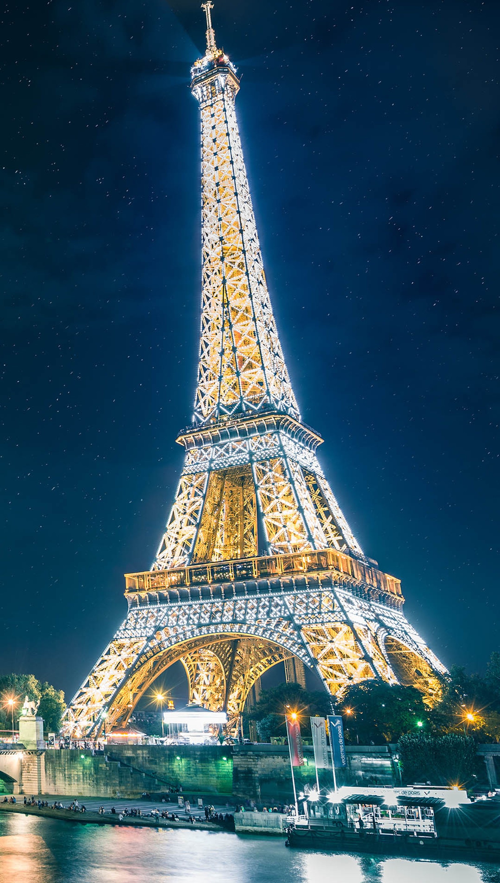 Vista de la torre eiffel de noche con un barco en el agua (dhfm, hsds)