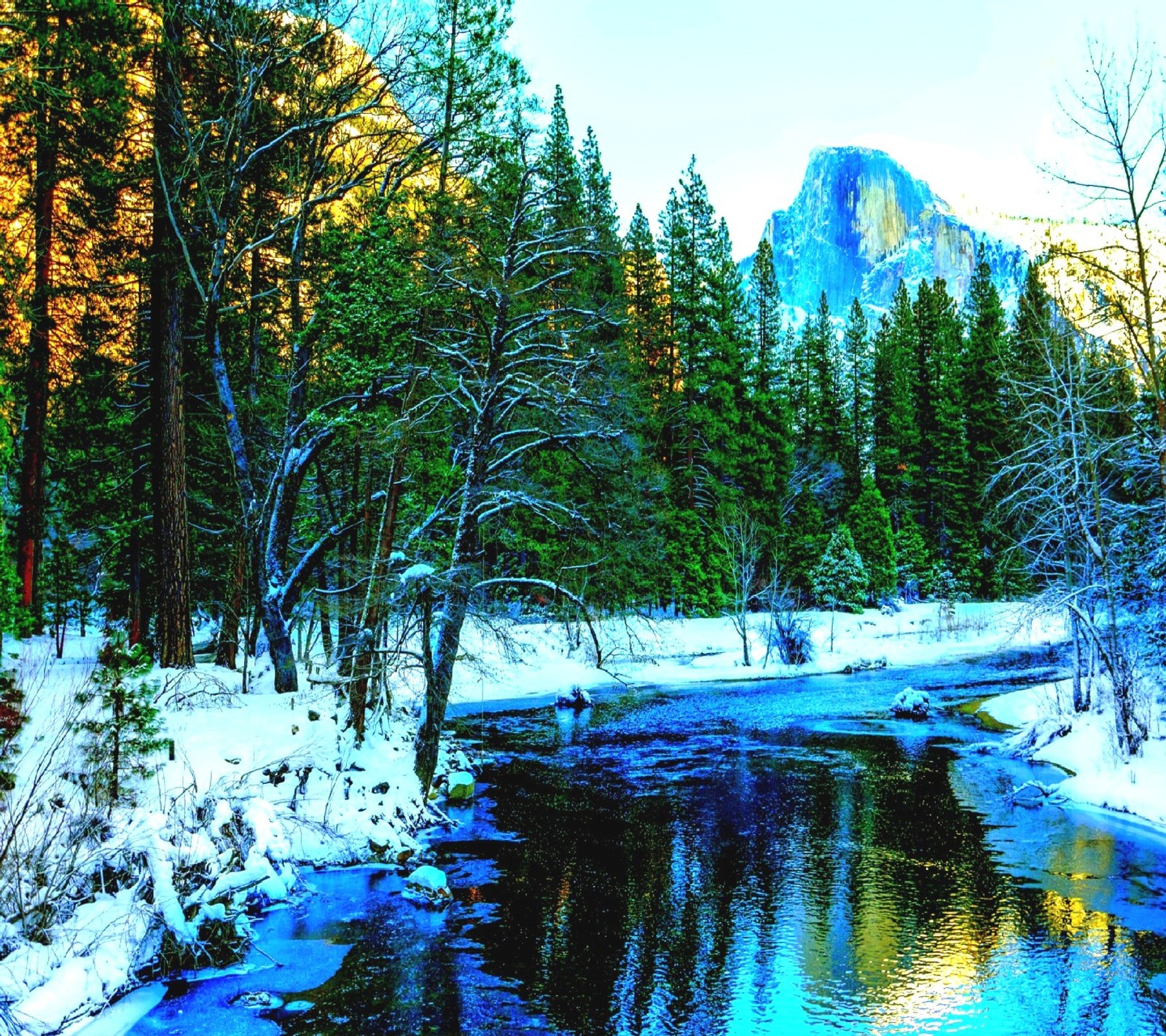 Un gros plan d'une rivière avec de la neige au sol et des arbres (hiver)