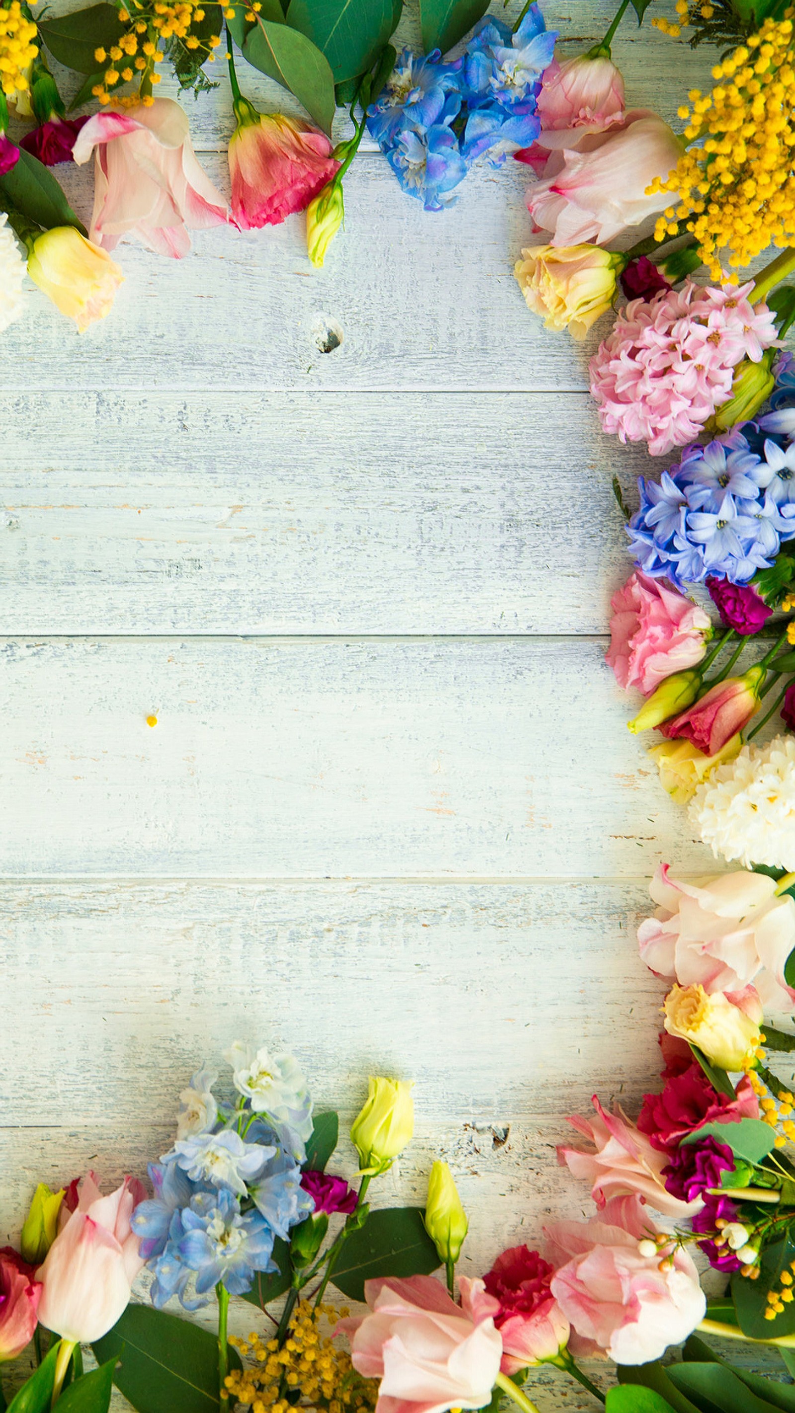 There is a wreath of flowers on a white wooden table (flower, nature, wood)