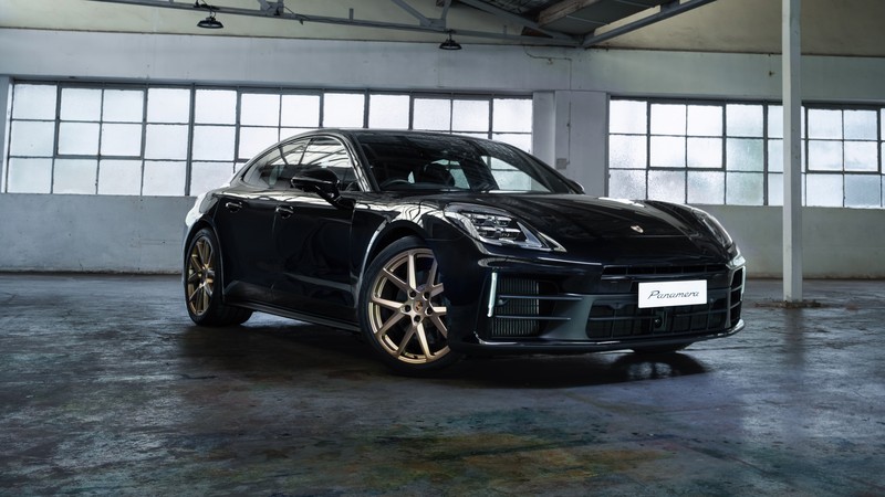 Черный porsche tay стоит в большом складе с множеством окон (porsche panamera, 2024, машины, обои 4k)