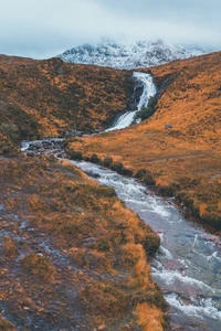 Paysage serein de haute montagne avec cascade et sommets montagneux