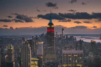 Paisaje urbano al atardecer: El edificio Empire State iluminado contra el horizonte de Nueva York